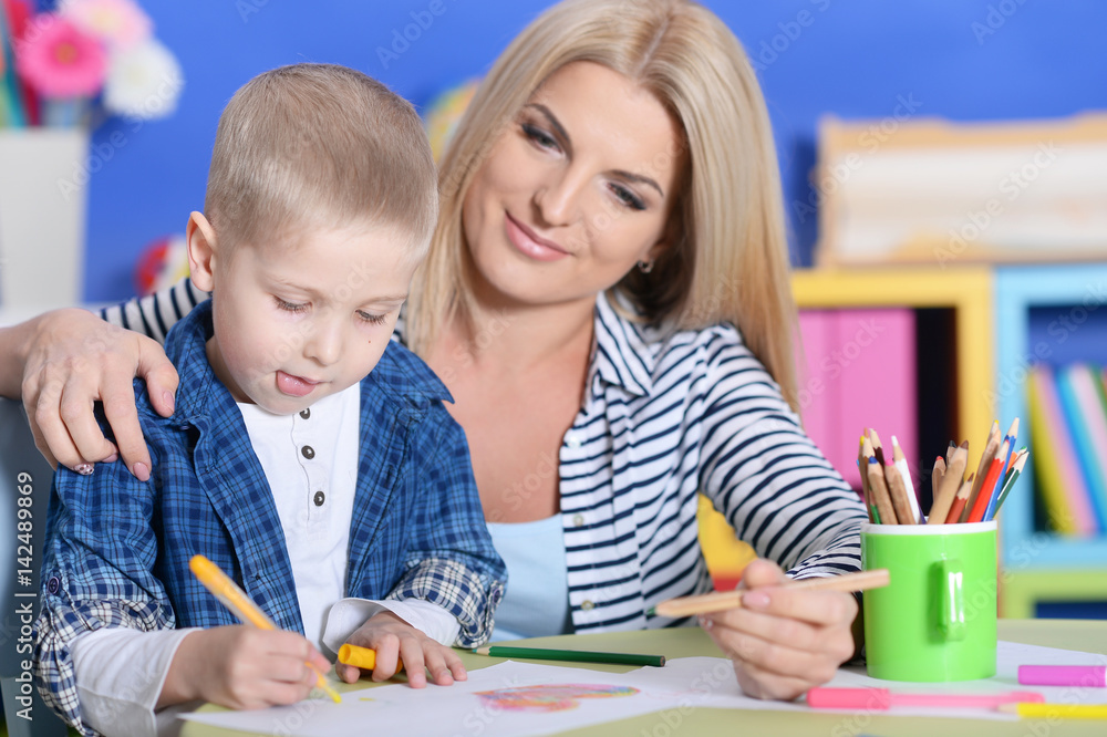 Boy drawing with his mother