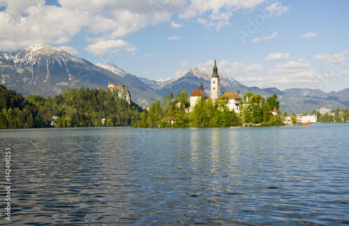 Pilgrimage church and rocktop castle with mountain landscape background, Bled lake, Slovenia photo