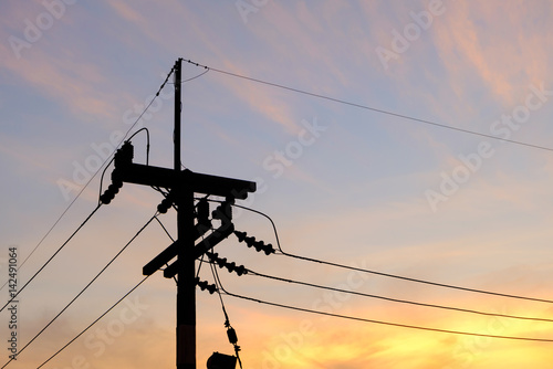 Silhouette electric pole with twilight sky background photo