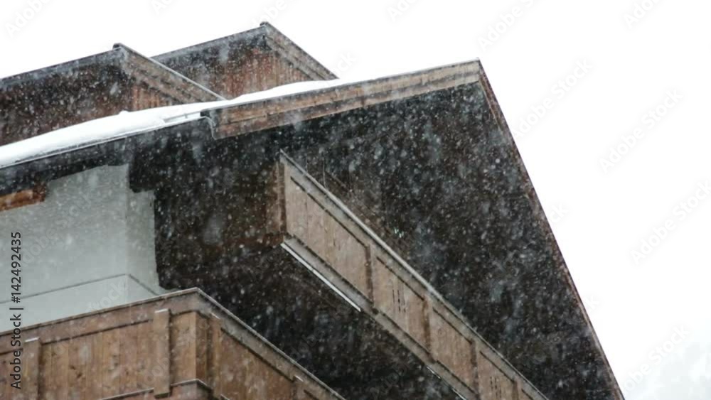Low angle view of heavy snow falling outside a dark wooden ski chalet in Obergurgl, Austria Low angle view of heavy snow falling outside a dark wooden ski chalet in Obergurgl, Austria