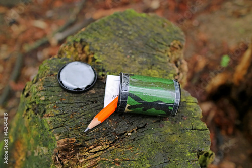 Geocache-Dose mit Logbuch und Bleistift