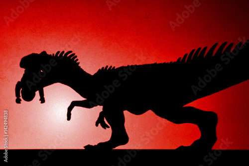 red spot light shadow of allosaurus biting a body  on wall no logo or trademark