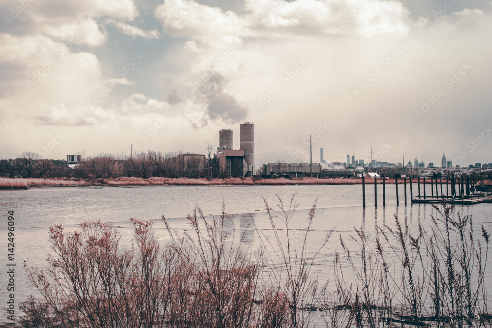 Power plant energy silos. Industrial energy smoke stacks. Dried up low tide lake with mud bank. Swamp waterfront bay area. Industrial design and infrastructure. Architectural detail. Isolated plant.