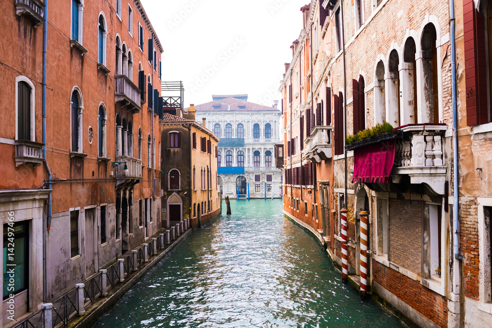 Water canal and venetian buildings in its typical architecture in Venice, Italy.