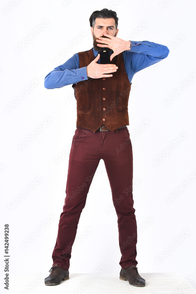 bearded man holding perfume with serious face bearded man holding perfume with serious face