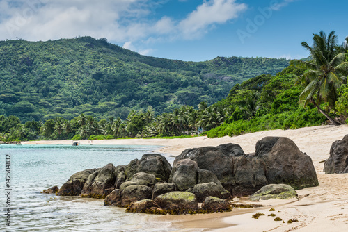 Tropical beach Anse Royale with granite boulders in the foreground at Mahe island, Seychelles - vacation background.