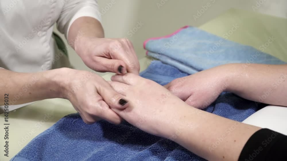 Beautician is applying creme to woman's hands in beauty salon closeup Beautician is applying creme to woman's hands in beauty salon closeup