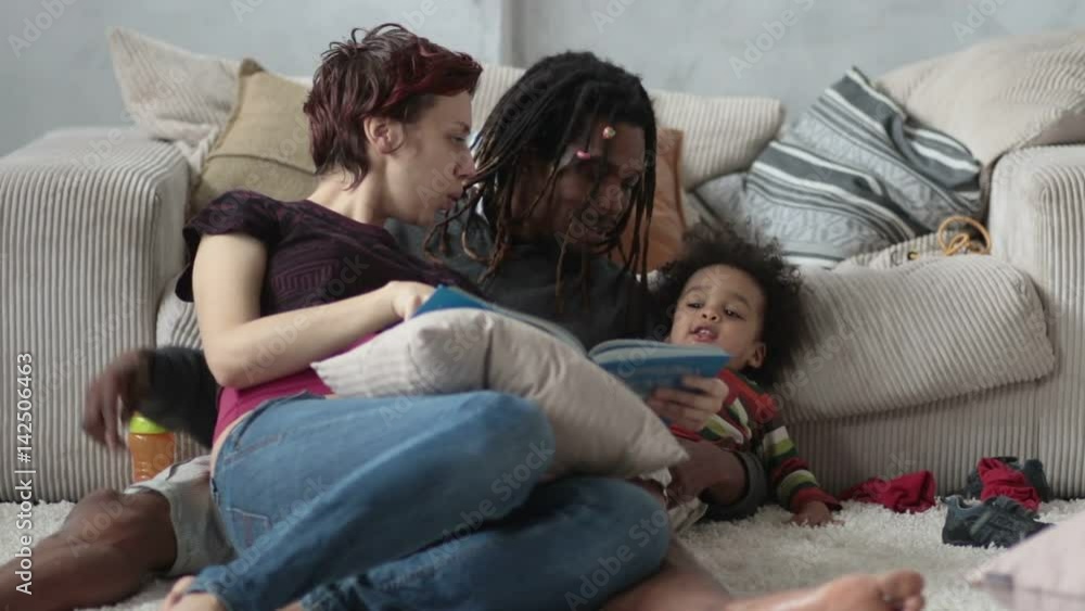 Family sitting on floor reading story together Family sitting on floor reading story together
