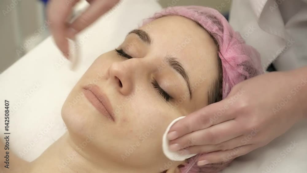 Beautician is applying a facial anti-aging mask Beautician is applying a facial anti-aging mask