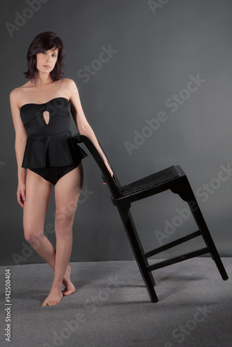 Woman in Black Bodysuit With Black Chair