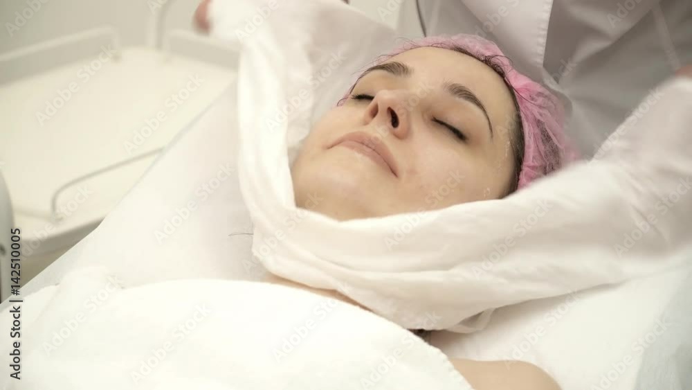 Beautician is clearing a facial anti-aging mask Beautician is clearing a facial anti-aging mask
