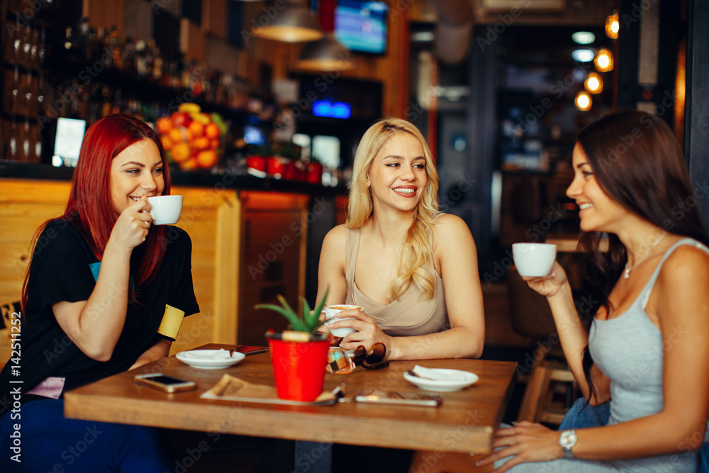 Gossip girls in a cafe drinking coffee