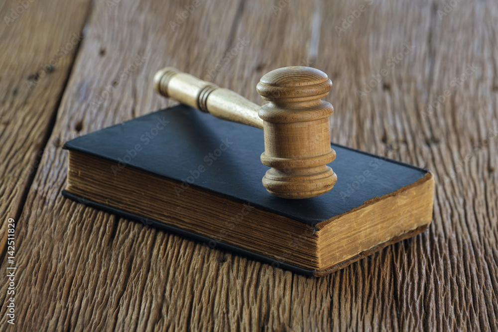 Judge's gavel with old book on old wood table Judge's gavel with old book on old wood table