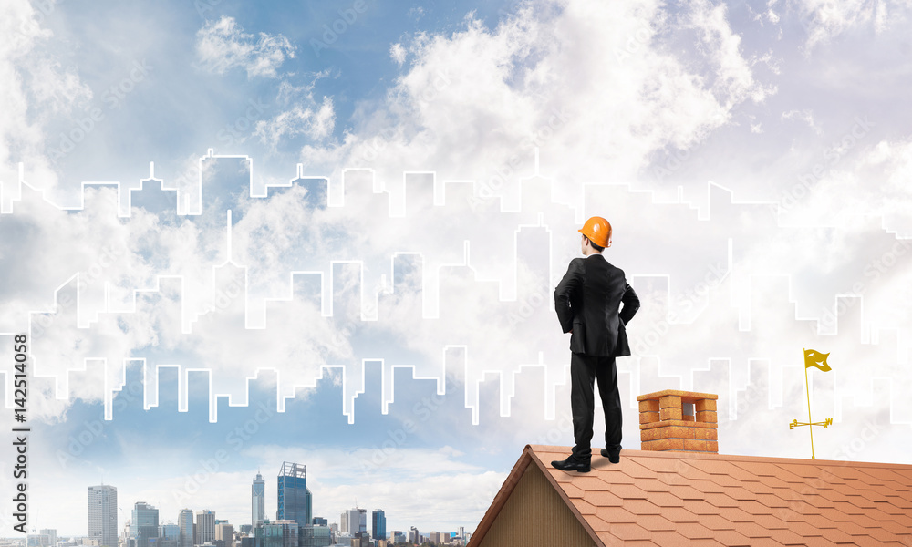 Engineer man standing on roof and looking away. Mixed media Engineer man standing on roof and looking away. Mixed media