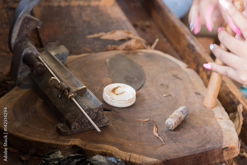 Closeup of hands making cigar from tobacco leaves. Traditional manufacture of cigars. Dominican Republic Closeup of hands making cigar from tobacco leaves. Traditional manufacture of cigars. Dominican Republic