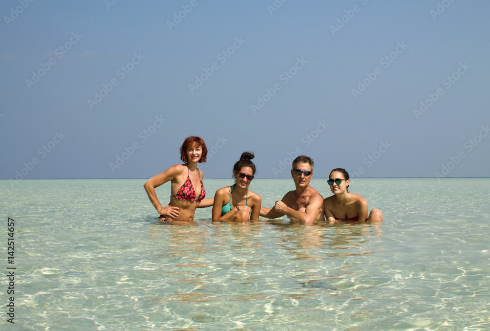 happy family posing together in the transparent sea, Indonesia