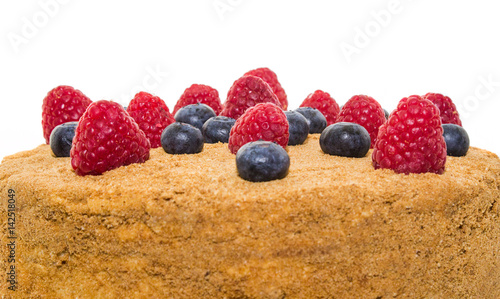 Honey cake decorated with raspberries and blueberries isolated.