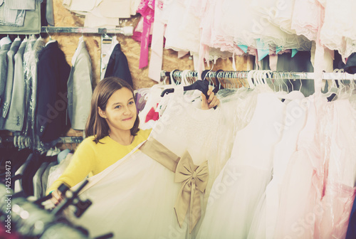 Little girl deciding on pretty dress © JackF