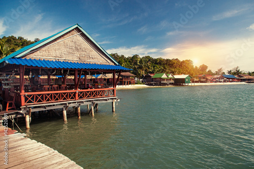 Outdoor restaurant on tropical beach wooden chairs and tables at sunshine, Cambodia