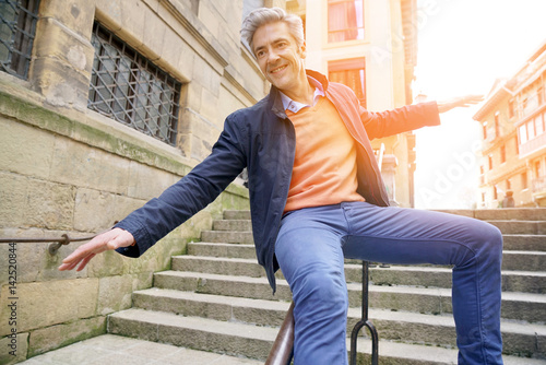 Man having fun sliding down staircase ramp