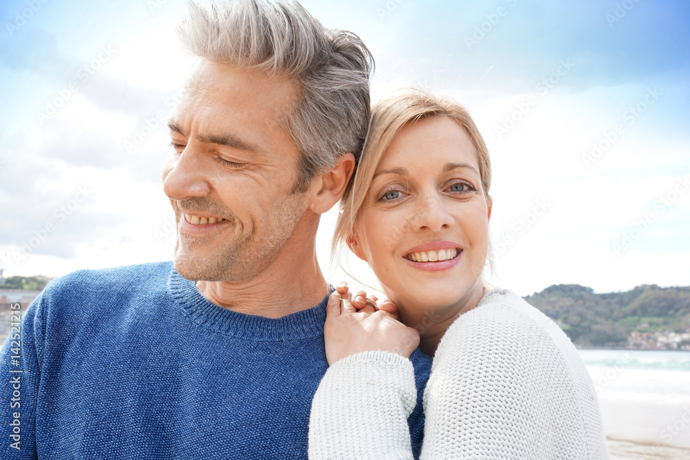 Middle-aged couple embracing each other at the beach Middle-aged couple embracing each other at the beach