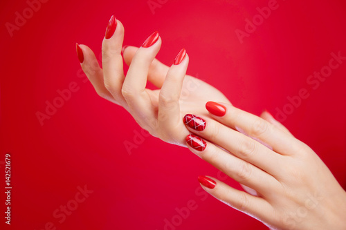 Cuadro en lienzo Beautiful manicured woman's hands on red background.