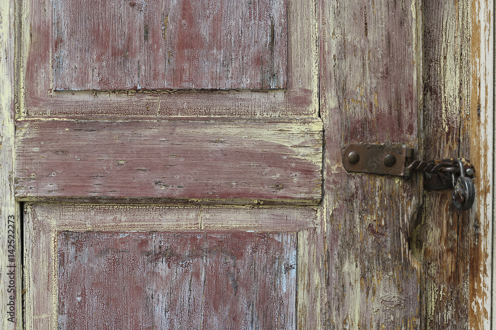 Extract of colorful weathered door with padlock