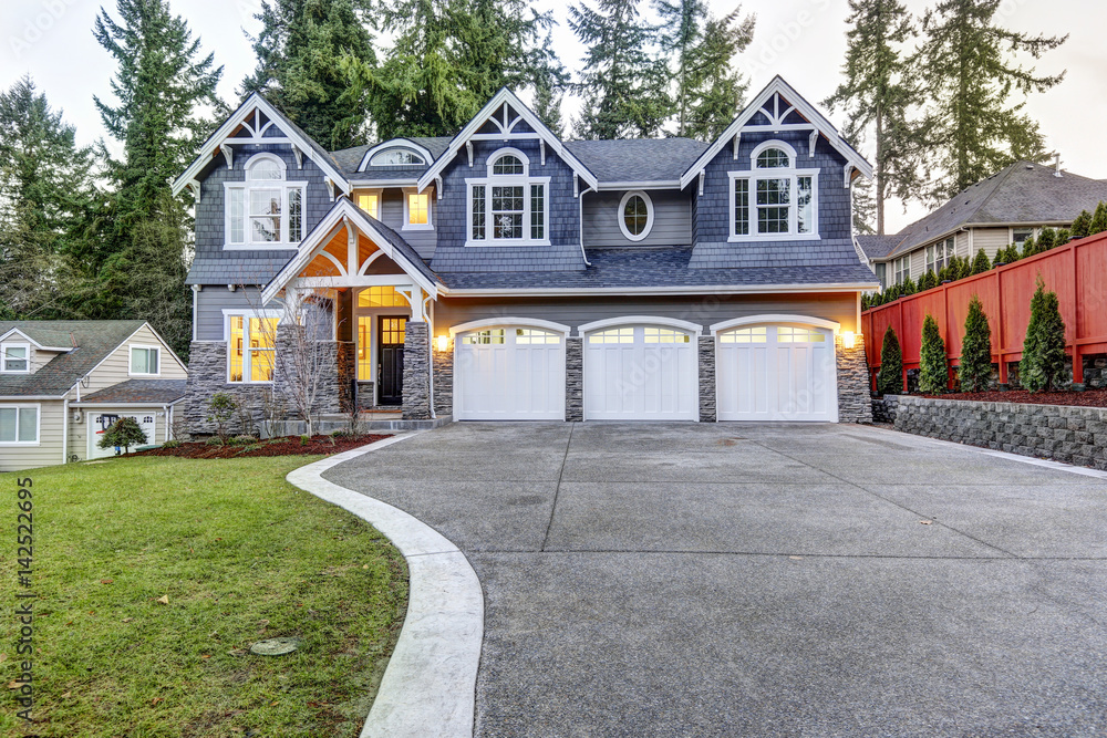 Luxurious blue home with three attached garage spaces