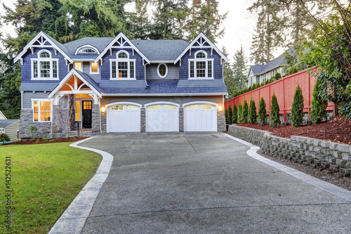 Luxurious blue home with three attached garage spaces