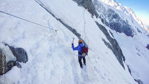 Mountaineer arrive at Couloir passage on the way to the Montblanc summit. Concepts: determination, courage, effort, self-realization. Sunny winter day, european Alp
