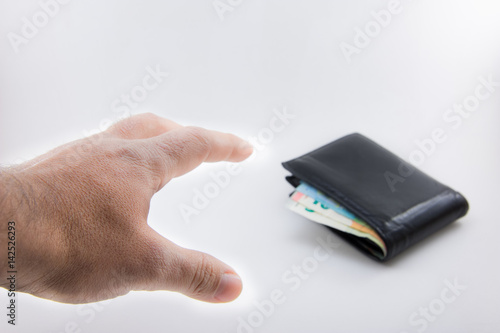 A hand is trying to steel a wallet with some euro money. Isolated on white.