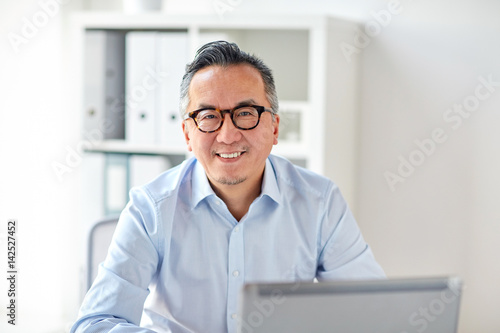 happy businessman in eyeglasses with laptop office