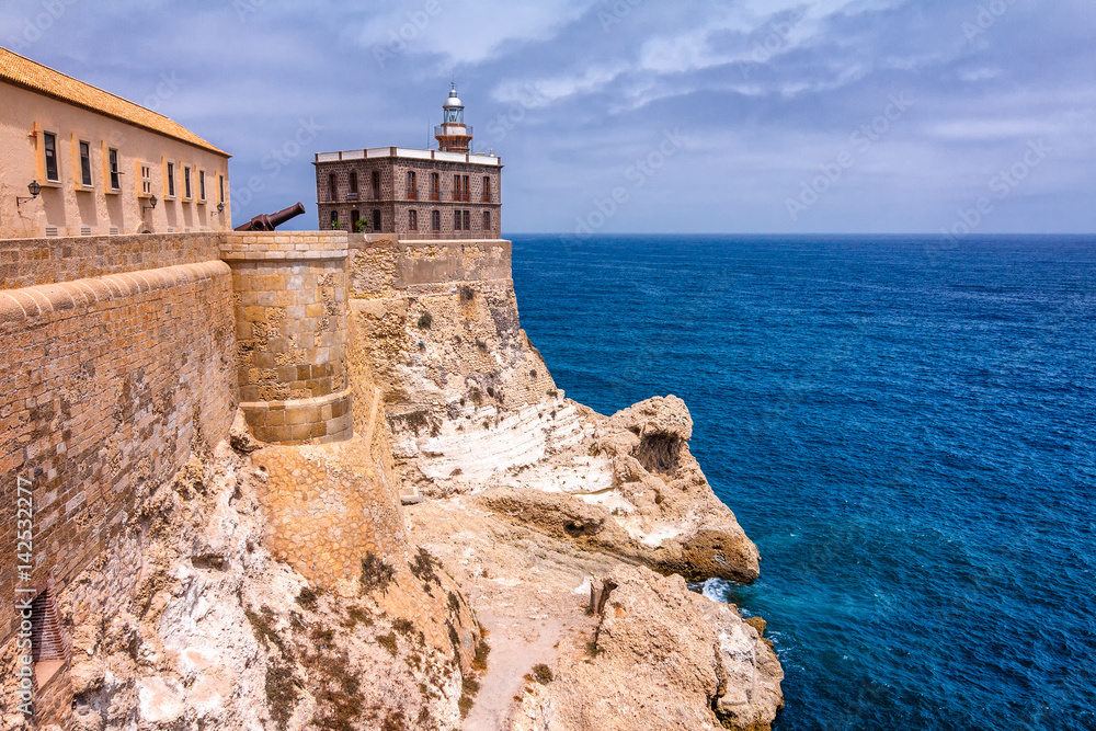 Lighthouse in harbor Melilla, Spanish province in Morocco. The rocky coast of the Mediterranean Sea.
