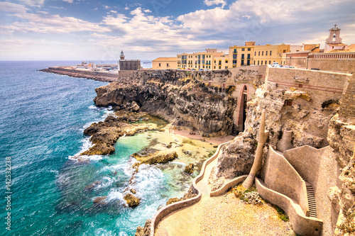 City walls, lighthouse and harbor in Melilla, Spanish province in Morocco. The rocky coast of the Mediterranean Sea.