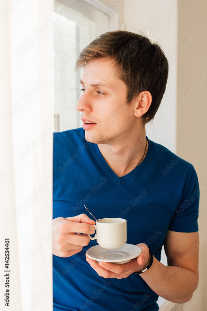 Man drinking coffee looking out the window Man drinking coffee looking out the window