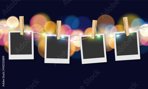 Hanging blank photo frame on soft bokeh and lights background