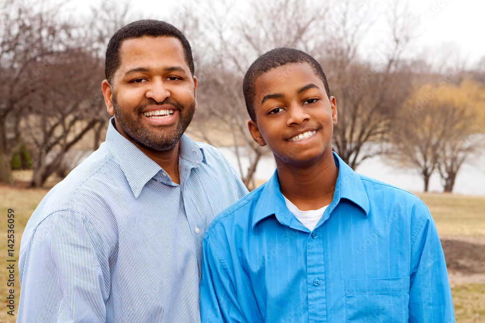 African American father and his teenage son. African American father and his teenage son.