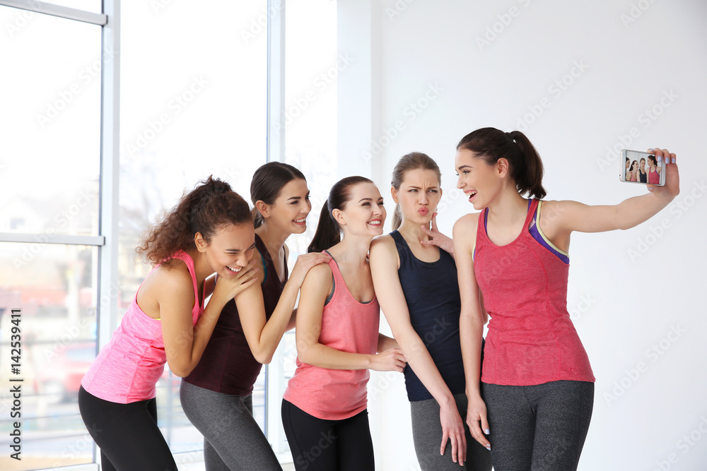 Fototapeta premium Young sporty women taking selfie at training
