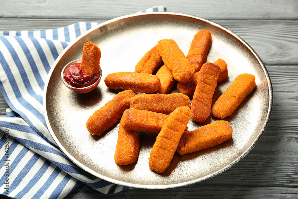 Metal plate with cheese sticks and ketchup sauce on table