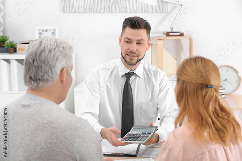 Insurance agent showing calculator with value of benefits photo