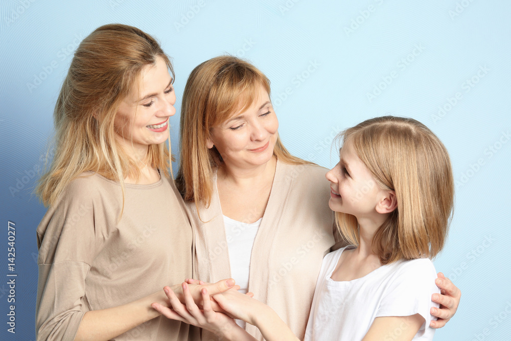 Happy young woman with her mother and daughter on color background Happy young woman with her mother and daughter on color background