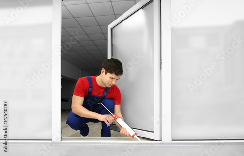 Young worker sealing joints...