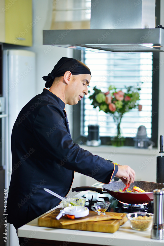 mature chef preparing a meal with various vegetables and meat mature chef preparing a meal with various vegetables and meat