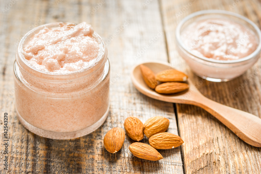 cosmetic set with almond scrub on table background cosmetic set with almond scrub on table background