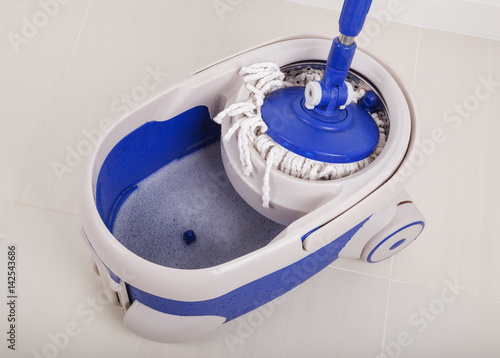 close up of mop and blue bucket for cleaning floor