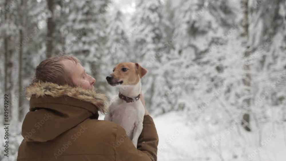 Man is Holding a Dog in The Winter Forest Man is Holding a Dog in The Winter Forest