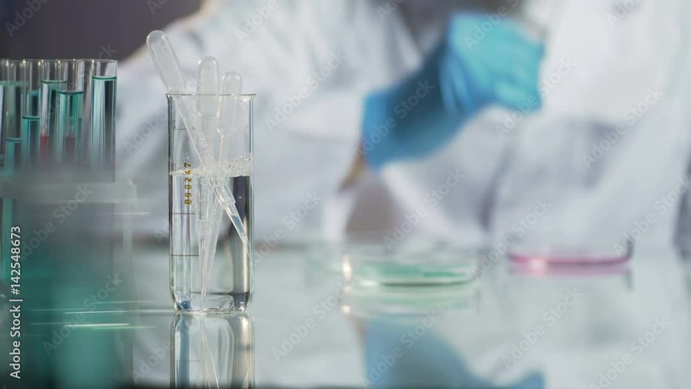Laboratory scientist conducting tests by adding drop of reagent to mixture Laboratory scientist conducting tests by adding drop of reagent to mixture