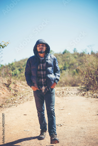 Hiker with backpack walking through forest enjoying adventure in holiday.