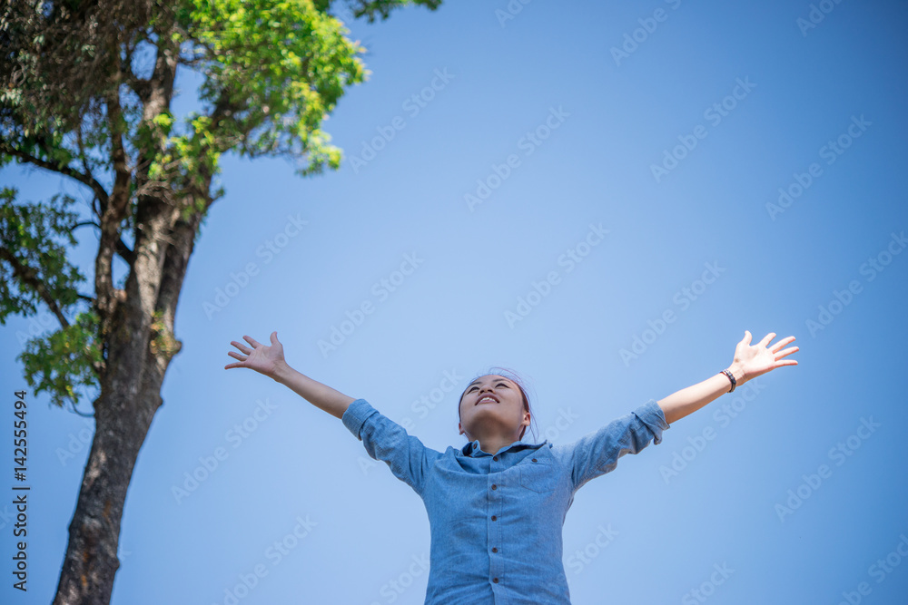 Young woman standing looking to a sky with raised hands while during hike in the mountain. Young woman standing looking to a sky with raised hands while during hike in the mountain.