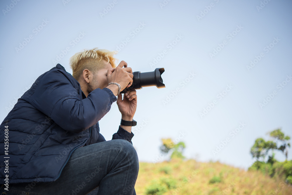 Young photographer sitting on his pickup truck photographing in mountain. Young photographer sitting on his pickup truck photographing in mountain.